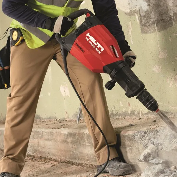 A man holding a large hammer on top of stairs.