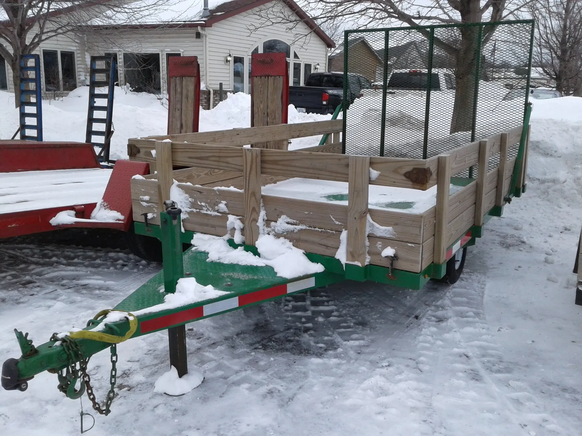 A trailer with wooden sides and green painted frame.