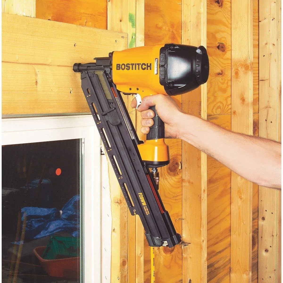 A person holding a nail gun in their hand.