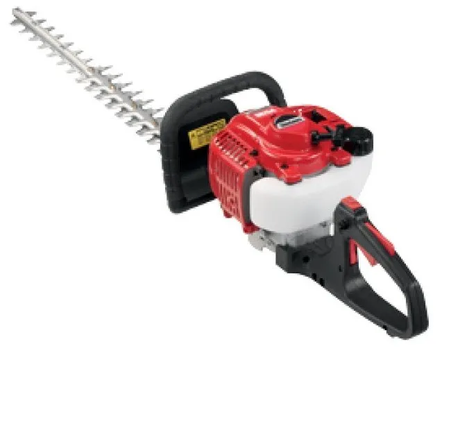 A red and black hedge trimmer is on the ground