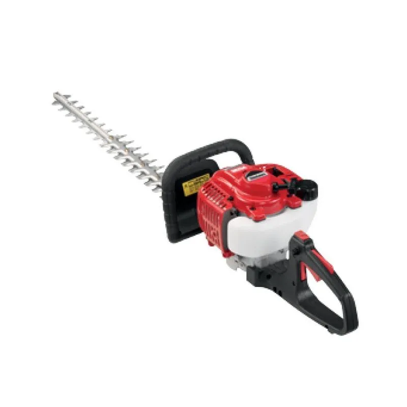 A red and black hedge trimmer is on the ground