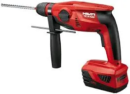 A red and black drill is on the floor