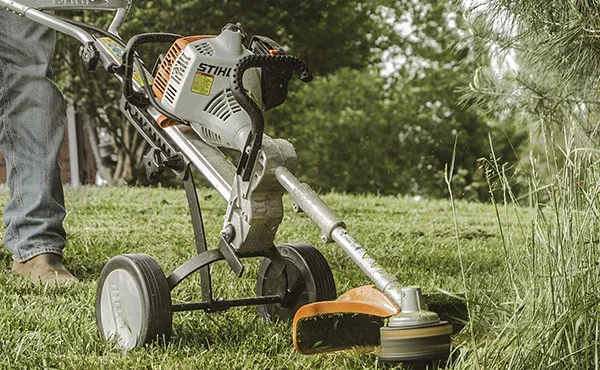 mm+trimmer-1920w A grass trimmer sitting in the middle of a field.