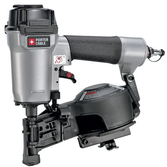 A power tools air nailer is sitting on top of a black and silver machine.