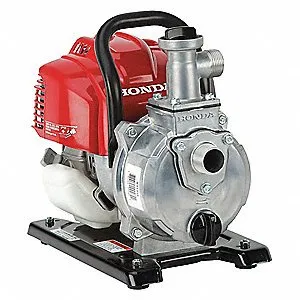 A honda water pump is sitting on the ground.