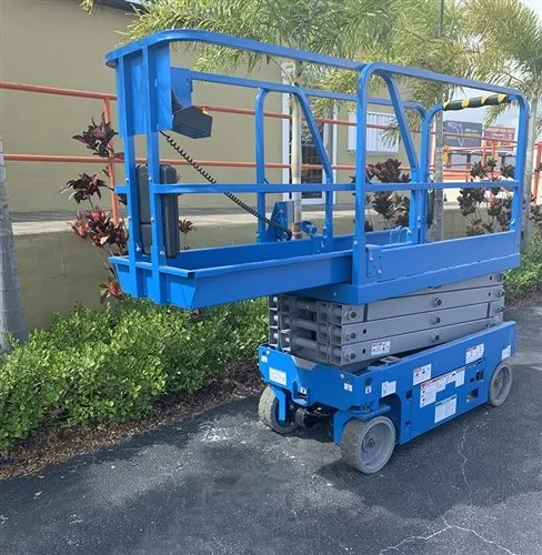 A blue scissor lift parked in the street.