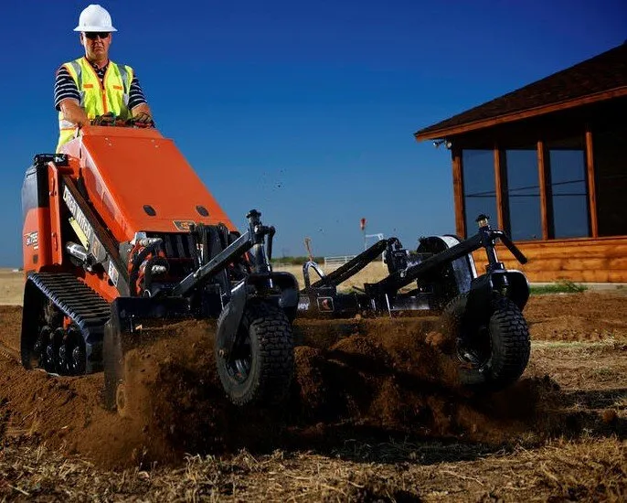 A man in an orange jacket is on a tractor.