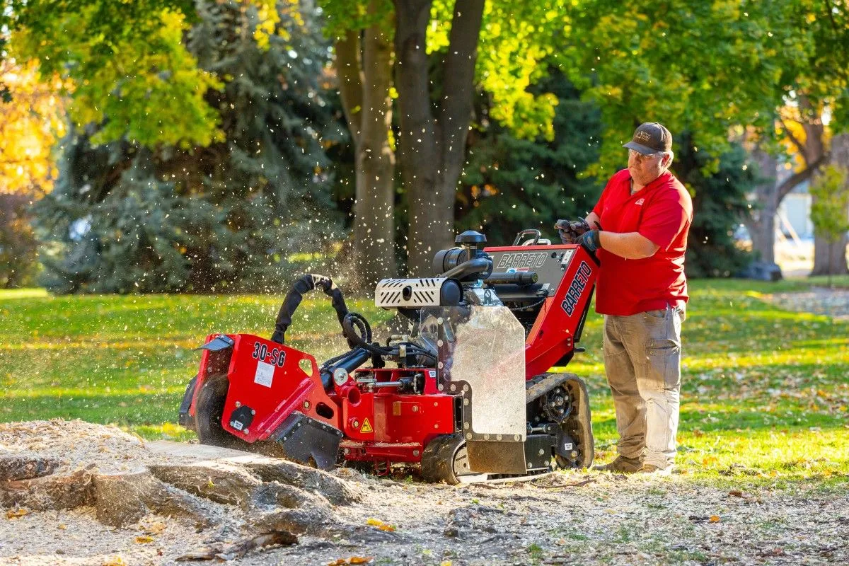 A man standing next to a red machine.